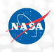 NASA’s round blue logo, known as the “meatball,” featuring white letters “NASA,” a red swoosh, and white orbit lines, is centered on a light, slightly textured background.