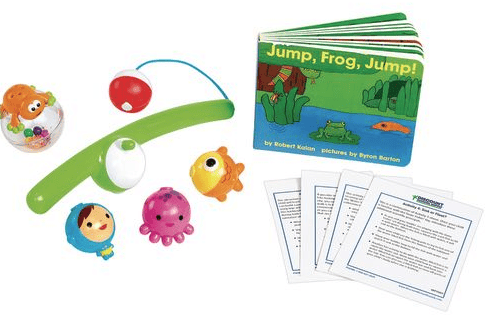 A set of colorful toys including sea animal figures, a rattle, a green handle with hanging toys, a board book titled Jump, Frog, Jump! and a few instructional cards with text.